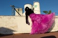 Woman dressed in black dress and pink skirt, unrecognisable with mask Royalty Free Stock Photo