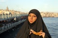Woman dressed black headscarf, chador eating simit, istanbul, turkey Royalty Free Stock Photo