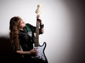 Woman squatting and clutching guitar Royalty Free Stock Photo