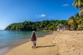 Woman dressed in a costume and hat walking in a tropical beach in Trinidad and Tobago