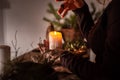 A woman dressed in a medieval dress holds a burning white candle in her hand. Mystery witch Royalty Free Stock Photo