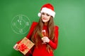 Woman dressed in red dress and santa hat with a pres Royalty Free Stock Photo