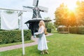 Woman dressed on traditional Dutch dress wooden shoes yellow clogs hanging Clothes on clothesline outside. laundry Royalty Free Stock Photo