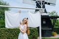 Woman dressed on traditional Dutch dress wooden shoes yellow clogs hanging Clothes on clothesline outside. laundry Royalty Free Stock Photo