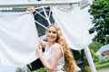 Woman dressed on traditional Dutch dress wooden shoes yellow clogs hanging Clothes on clothesline outside. laundry Royalty Free Stock Photo