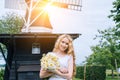 Woman dressed on traditional Dutch dress, wooden shoes yellow clogs klompen holding bouquet of Chamomile flowers with Royalty Free Stock Photo