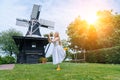 Woman dressed on traditional Dutch dress, wooden shoes yellow clogs klompen holding bouquet of Chamomile flowers with Royalty Free Stock Photo