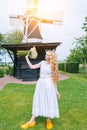 Woman dressed on traditional Dutch dress, wooden shoes yellow clogs klompen holding bouquet of Chamomile flowers with Royalty Free Stock Photo