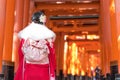 Woman dressed in traditional japanese costume walking under Red Royalty Free Stock Photo