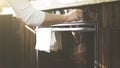 A woman adjusts temperature on the kitchen oven