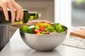 Woman dressing fresh vegetable salad with olive oil in kitchen Royalty Free Stock Photo