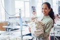 Woman dressmaker stands in the factory with cloth in hands