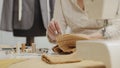 Woman dressmaker working in workshop with tailoring mannequin, sews by hand the sweater. closeup, with tailoring mannequin,