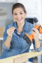 Woman with drill in protective clothes doing home repair Royalty Free Stock Photo