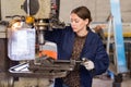 Woman drilling steel structures on drill press