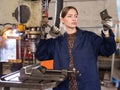 Woman drilling steel structures on drill press