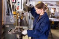 Woman drilling steel structures on drill press