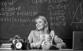 Woman drink coffee in classroom. teacher with alarm clock at blackboard. Time. Back to school. Teachers day. Study and Royalty Free Stock Photo