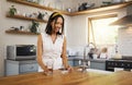 Woman drink medicine pills with a glass of water or supplement capsule in her kitchen apartment. Latino female in Royalty Free Stock Photo