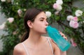 Woman drink water from sport bottle, doing stretching up exercise outdoors. Royalty Free Stock Photo