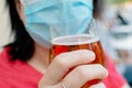 Woman drinking a beer with protective face mask on Royalty Free Stock Photo