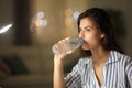 Woman drinking bottled water at home in the night Royalty Free Stock Photo