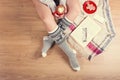 Woman drinking cappuccino coffee and sitting on the wooden floor. Close-up of female legs in warm socks with a deer with christmas Royalty Free Stock Photo