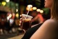 Woman drinking a cocktail at a summer party in a restaurant close-up. woman holding cold drink with her Royalty Free Stock Photo