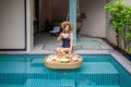 Woman drinking coffee and floating breakfast in villa swimming pool Royalty Free Stock Photo