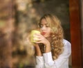 Woman drinking coffee indoors, enjoying the aroma of beverage Royalty Free Stock Photo