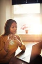 Woman drinking coffee and looking at laptop