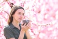 Woman drinking coffee in a pink field Royalty Free Stock Photo
