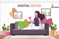 Woman drinking coffee relaxing on sofa digital detox concept girl abandoning social networks