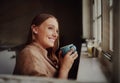 Beautiful young woman isolated at home smiling drinking coffee and daydreaming Royalty Free Stock Photo