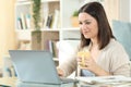 Woman drinking coffee using a laptop at home Royalty Free Stock Photo