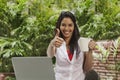 Woman drinking coffee, using a laptop and showing a thumbs up si Royalty Free Stock Photo