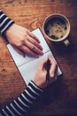 Woman drinking coffee and writing a diary note