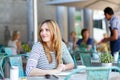 Woman drinking coffee and writing notes in cafe Royalty Free Stock Photo