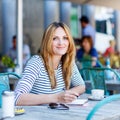 Woman drinking coffee and writing notes in cafe Royalty Free Stock Photo