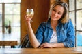 A woman drinking fresh craft cider from the tap, holding up her glass to cheers her friends at the bar