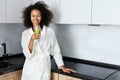 Woman drinking green detox juice, smoothie drink in kitchen Royalty Free Stock Photo