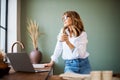 Woman drinking her coffee in the kitchen at the morning while daydreaming Royalty Free Stock Photo