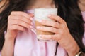 Woman drinking hot cappuccino coffee and eating cake at a cafe. Royalty Free Stock Photo