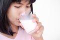 Woman drinking milk from glass close up on white bakcground. Portrait authentic skin tan asian lady. fast food for good health in