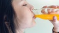 Woman drinking orange juice from a clean bottle. The skin is smooth and beautiful. concept of healthy women, on white background. Royalty Free Stock Photo