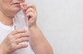 Woman drinking potassium iodide tablet and levothyroxine sodium, for the treatment of the thyroid gland, close-up, copy space Royalty Free Stock Photo