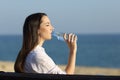 Woman drinking water from a bottle on the beach Royalty Free Stock Photo