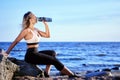 Female drinks water from bottle on shore during training. Royalty Free Stock Photo