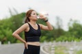 Woman drinking water after sport activities. Female exercising at outdoor park Royalty Free Stock Photo