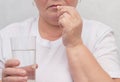 A woman drinks a hormonal pill for treating the thyroid gland, eliminating nodules and normalizing hormones, treatment, close-up Royalty Free Stock Photo